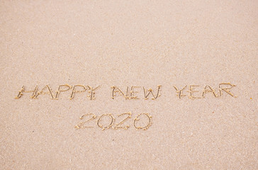 Happy New Year's  2020 writing in the sand  beach in the morning, appropriate the Backdrop idea copy space