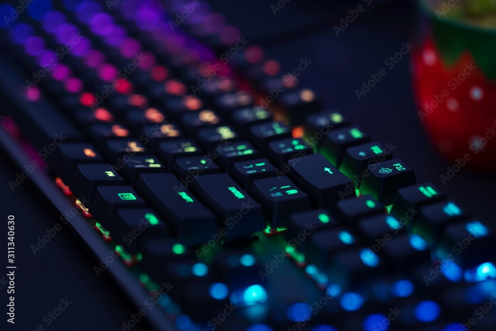 Poster close up of computer rgb gaming keyboard, illuminated by colored led