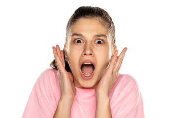 Portrait of young shocked woman without makeup on white background
