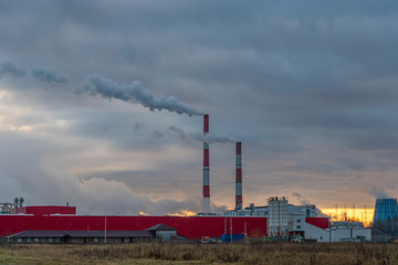 Fototapeta na wymiar Smoking factory chimneys against the sunset. Environmental pollution