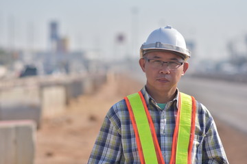 Senior Engineering holding tablet data technology working on road construction site