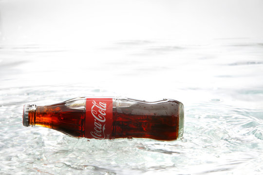 coca cola bottle on the water splash