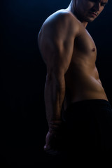 Obraz na płótnie Canvas cropped view of sexy muscular bodybuilder with bare torso on black background