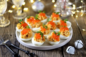 Stuffed eggs with salmon caviar. Christmas background.