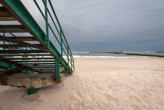 Stairs to an empty beach on a rainy day on a cloudy day. Baltic Sea, Poland