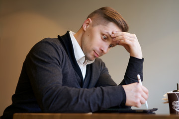 Businessman with tablet in hands sitting at table