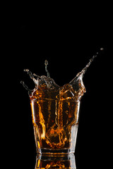 Glasses of whiskey with splash, isolated on black background