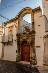 Scenic sight, street view from the beautiful town of Locorotondo, Bari province, Apulia, Puglia , Southern Italy. Amazing historical public building entrance, piece of art