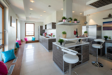Interior of kitchen in modern luxury studio apartment. Kitchen set. Chairs and table.