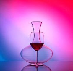 Jur for wine and glass with wine isolated on colorful background and mirror backdrop. Concept...