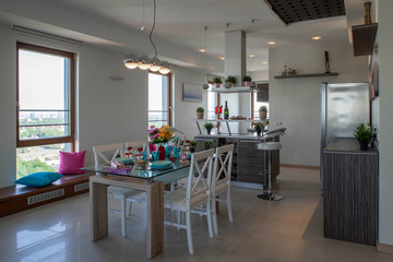 Interior of kitchen in modern studio apartment. Kitchen set and laid table. Luxury interior.