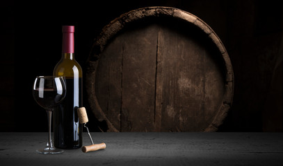 Pouring red wine into the glass against wooden background