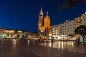 Fototapeta na wymiar Nigt view of the main square and old town architecture. travel and tourism concept, central market square of Krakow, Poland Bazylika Mariacka. Romantic atmosphere. Copy space