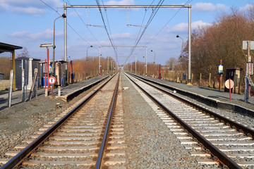 Obraz premium Perspective view on two railway tracks in a rural scene in Belgium Flanders