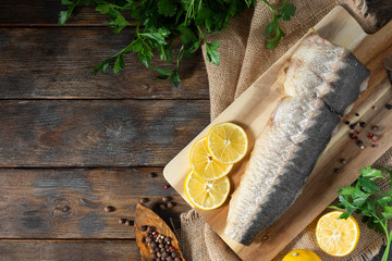 Hot smoked sturgeon on a wooden Board on a brown wooden table. Top view with copy space. Rustic...