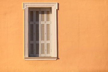 Old window shutters on orange home