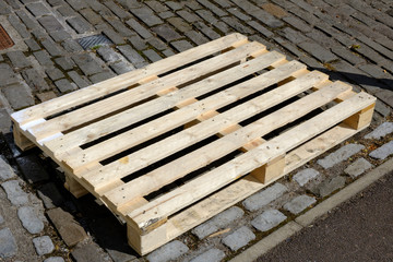 Empty plain wooden pallet placed on cobbles