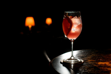 Pink color alcoholic cocktail drink decorated with a grapefruit slice