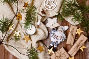 Cozy Winter Composition. Christmas Gifts, Gold Stars, Warm Knitted Sweater on Wood Background....