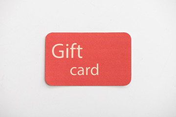 Top view of red gift card on white surface