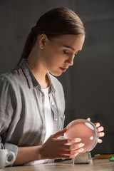Side view of beautiful astrologer using crystal ball at table
