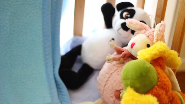 Vivid plush toys in a baby cot.