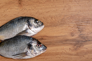 Fresh raw dorado fish with spices. Ingredients for cooking or grill on cutting board. Top view, copy space