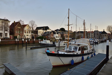 Fototapeta na wymiar Marina i zacumowane jachty wśród domów mieszkalnych o wschodzie słońca.
