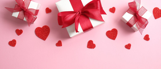 Valentine's Day background with white gift boxes decorated red ribbon bow and red hearts. Valentines day concept