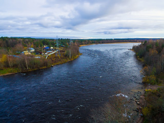 Fototapeta na wymiar Drone view of the Vuoksi river, the forest and the settlement in autumn day, Losevo, Leningrad Oblast, Russia