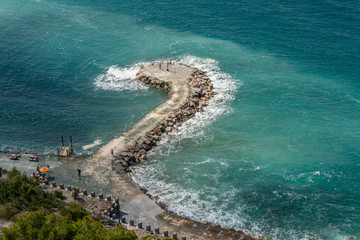 Fototapeta na wymiar pier with stones leaving in the sea. Cote d'Azur and the embankment