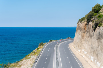 Turning mountain highway with blue sky and sea on a background. Top view