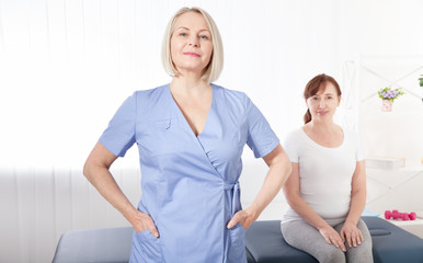 Obraz premium Physiotherapist smiling at camera in medical office