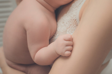 Children's hand close-up. Mother with a baby in her arms. Moment of tenderness.
