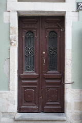 Vintage brown wooden door with forging elements.