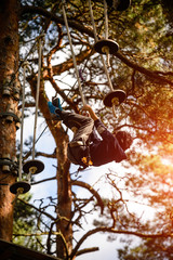 adventure climbing high wire park - people on course in mountain helmet and safety equipment