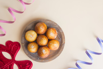 Carnival italian fritters in carnival on brown background