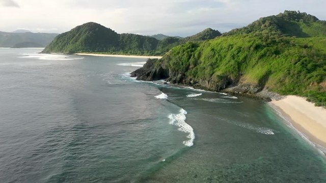 Gently foamy waves washing on the white sandy beach, Pantai Beach, Semeti , Lombok, Bali, Indonesia, Aerial drone establishing shot