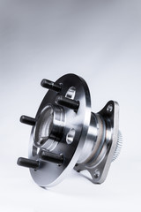 New Wheel hub assembly with bearing. This is part of the car suspension on a gray background with a gradient. The concept of new car parts