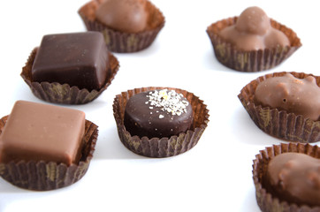 chocolate candies in a candy wrapper on a white background. A set of sweets with different tastes ..