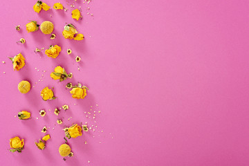 Flowers composition. Frame made of yellow rose flowers on pink background. Flat lay, top view, copy space