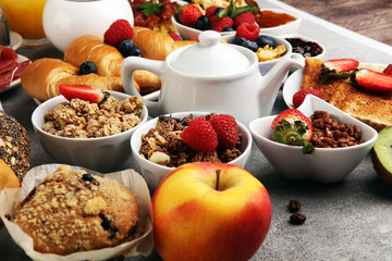 Breakfast served with coffee, orange juice, croissants, cereals and fruits. Balanced diet. Continental breakfast with granola and fruits