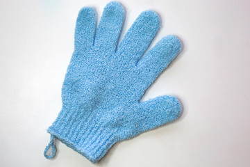 Blue massage scrub glove for shower on white background.  