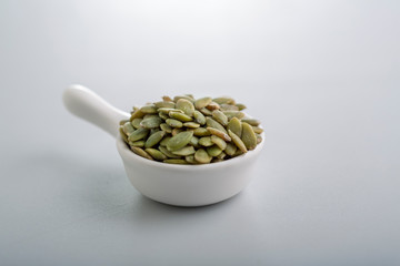Dry pumpkin seeds in a small cup