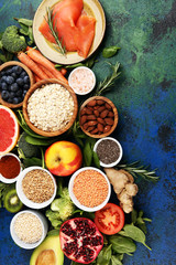 Healthy food clean eating selection: fish, fruit, vegetable, cereal, leaf vegetable on rustic background