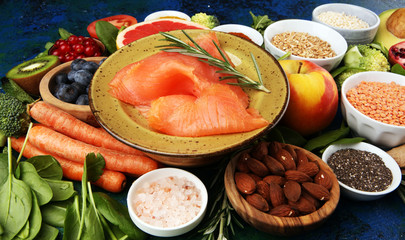 Healthy food clean eating selection: fish, fruit, vegetable, cereal, leaf vegetable on rustic background