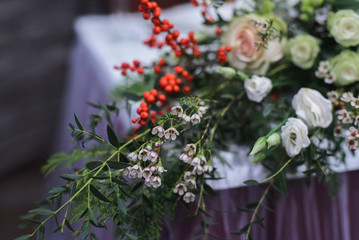 Obraz na płótnie Canvas marriage flower composition with waxflower, ilex, eustoma, pistachio on table for winter wedding indoors, close-up stock photo image