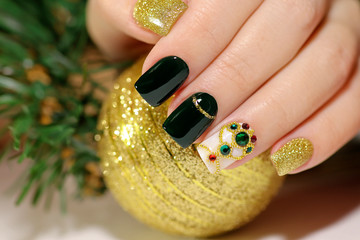 New year's fashionable beautiful festive manicure on short square nails with green lacquer color,...