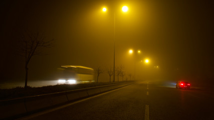 road lighting poles and car headlight on a foggy night