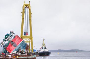Capsized ship vessel and rescue lift crane at port dock for repair of shipwreck